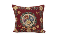 19th Century French needlepoint pillow featuring a classic floral wreath medallion on a deep burgundy ground.