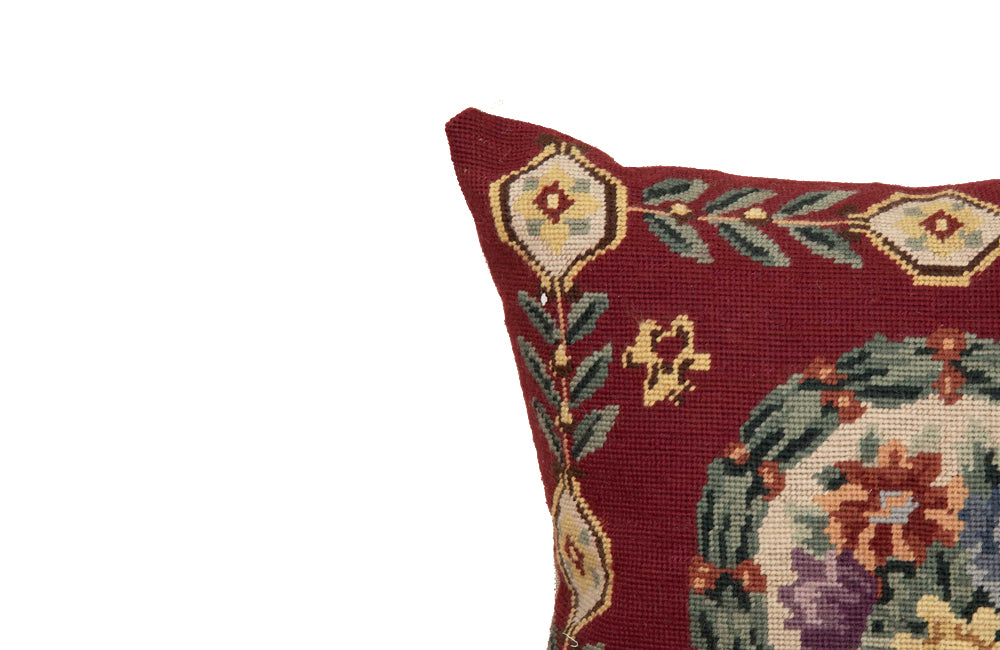 19th Century French needlepoint pillow featuring a classic floral wreath medallion on a deep burgundy ground.