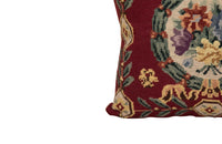 19th Century French needlepoint pillow featuring a classic floral wreath medallion on a deep burgundy ground.
