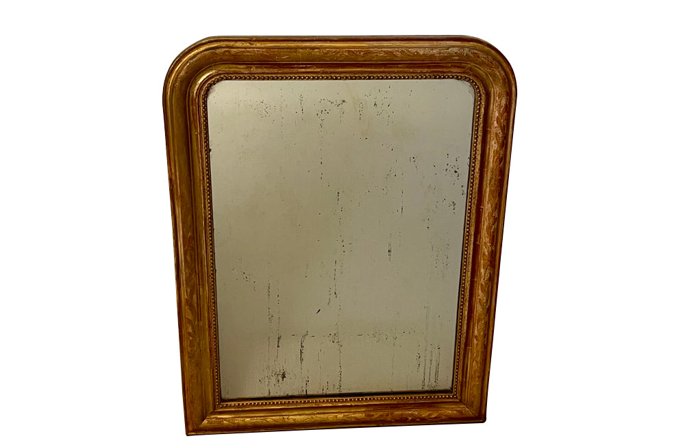 Antique mirror French Louis Philippe giltwood 19th Century with beaded inner surround and Neo-Classical foliate decoration to the frame.