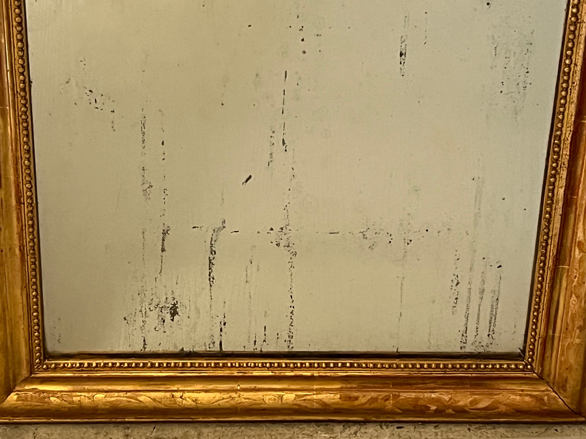 Antique mirror French Louis Philippe giltwood 19th Century with beaded inner surround and Neo-Classical foliate decoration to the frame.