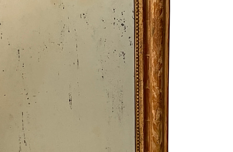 Antique mirror French Louis Philippe giltwood 19th Century with beaded inner surround and Neo-Classical foliate decoration to the frame.