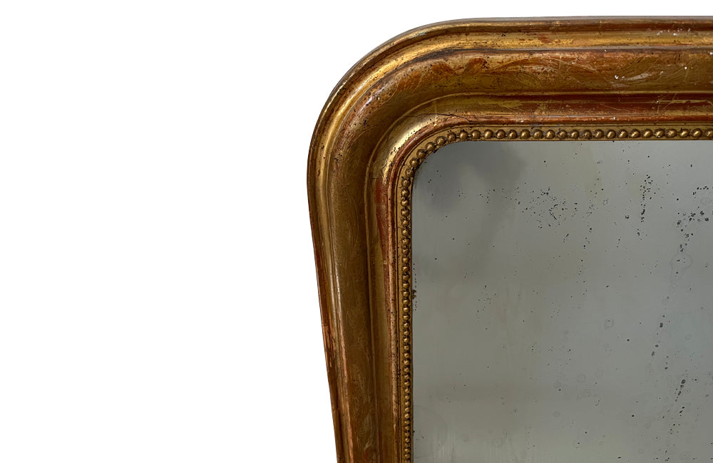 Antique mirror French Louis Philippe giltwood 19th Century with beaded inner surround and Neo-Classical foliate decoration to the frame.
