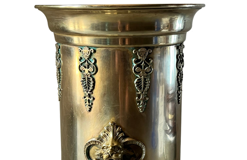 19th century brass umbrella or stick stand with lion head and bar handles and neo-classical style ornamentation.
