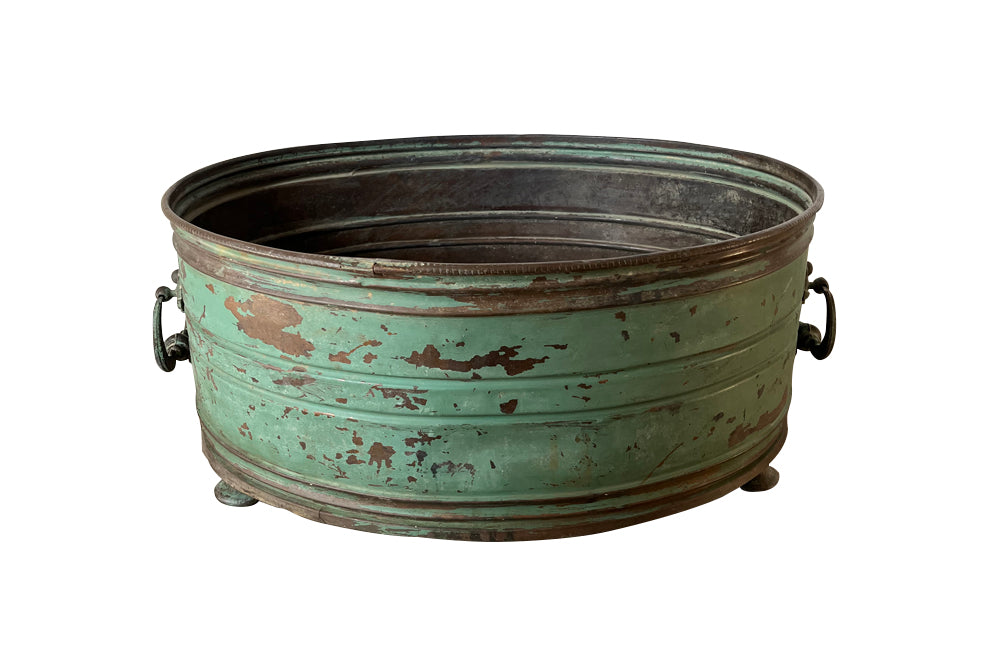 Large 19th century French copper jardiniere with worn verdigris coloured finish on three feet and two ornate swinging handles