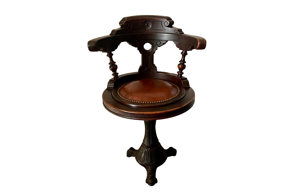 19th Century French carved wooden ships chair with leather seat and heavy cast iron base.