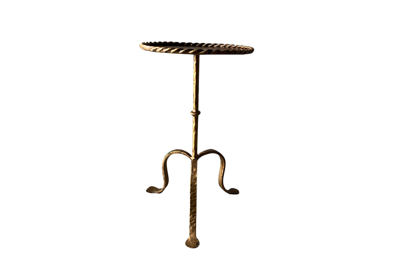 Chic, Spanish, gilt iron cocktail table with hammered and rope rim top on hammered ringed stem and decoratively shaped tripod base.