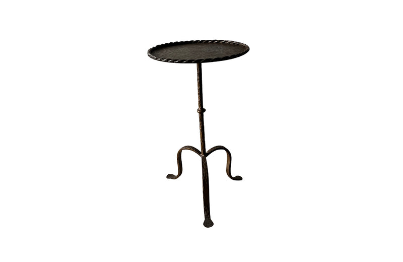 Spanish, gilt iron cocktail table with hammered and rope rim top on hammered ringed stem and decoratively shaped tripod base.