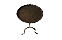 Spanish, gilt iron cocktail table with hammered and rope rim top on hammered ringed stem and decoratively shaped tripod base.