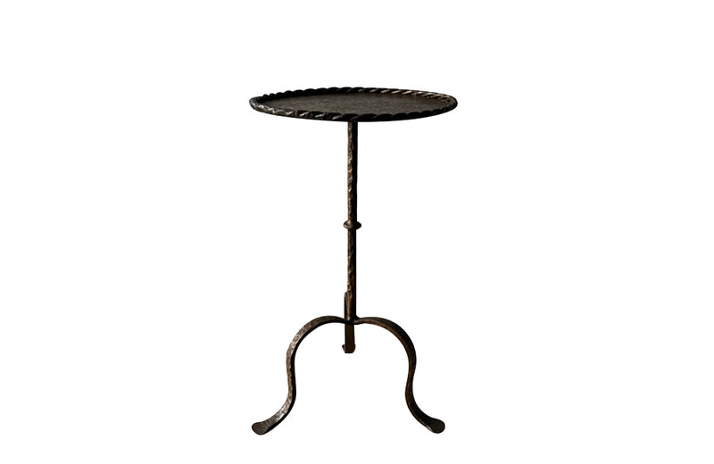 Spanish, gilt iron cocktail table with hammered and rope rim top on hammered ringed stem and decoratively shaped tripod base.