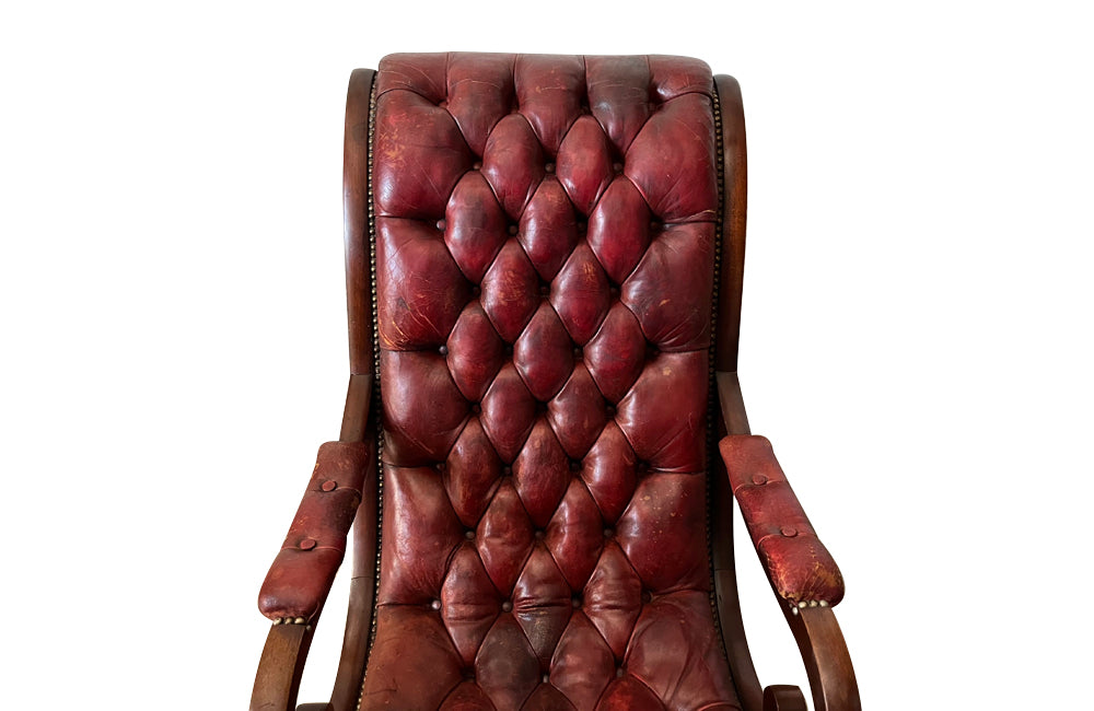 20th Century mahogany Regency Revival armchair with worn red buttoned leather.