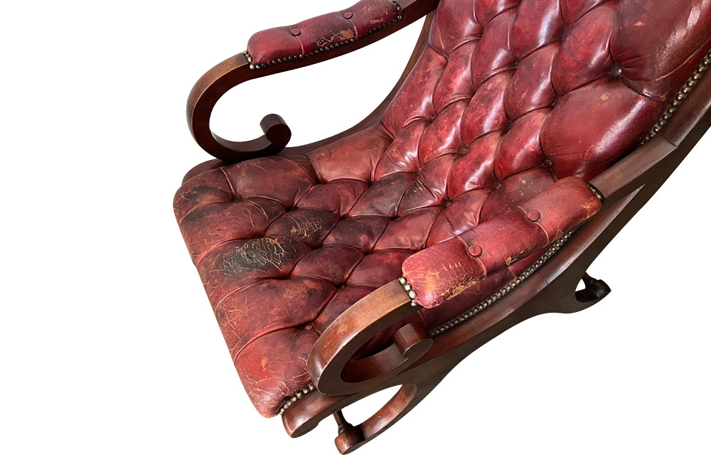 20th Century mahogany Regency Revival armchair with worn red buttoned leather.