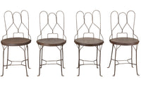 An elegant set of four mid-20th Century French wrought-iron folding chairs of the 'Bouchon de Champagne' type.