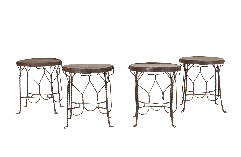 An elegant set of four mid-20th Century French wrought-iron folding chairs of the 'Bouchon de Champagne' type.
