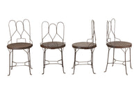 An elegant set of four mid-20th Century French wrought-iron folding chairs of the 'Bouchon de Champagne' type.