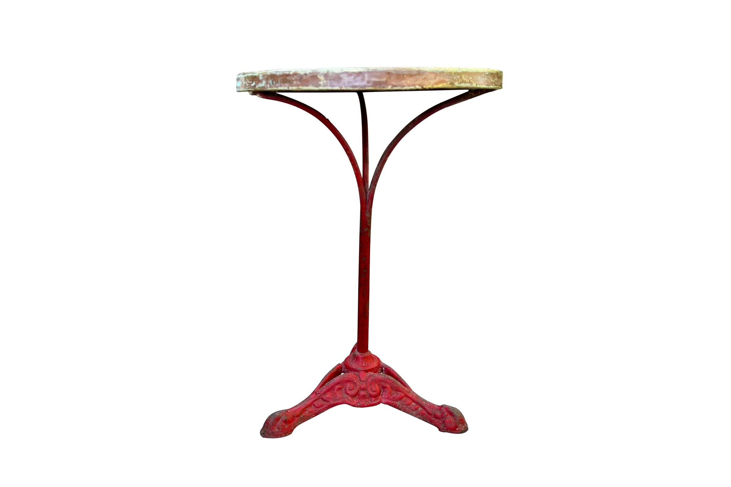 A pedestal table with a distressed red cast iron tripod base and a circular marble top 