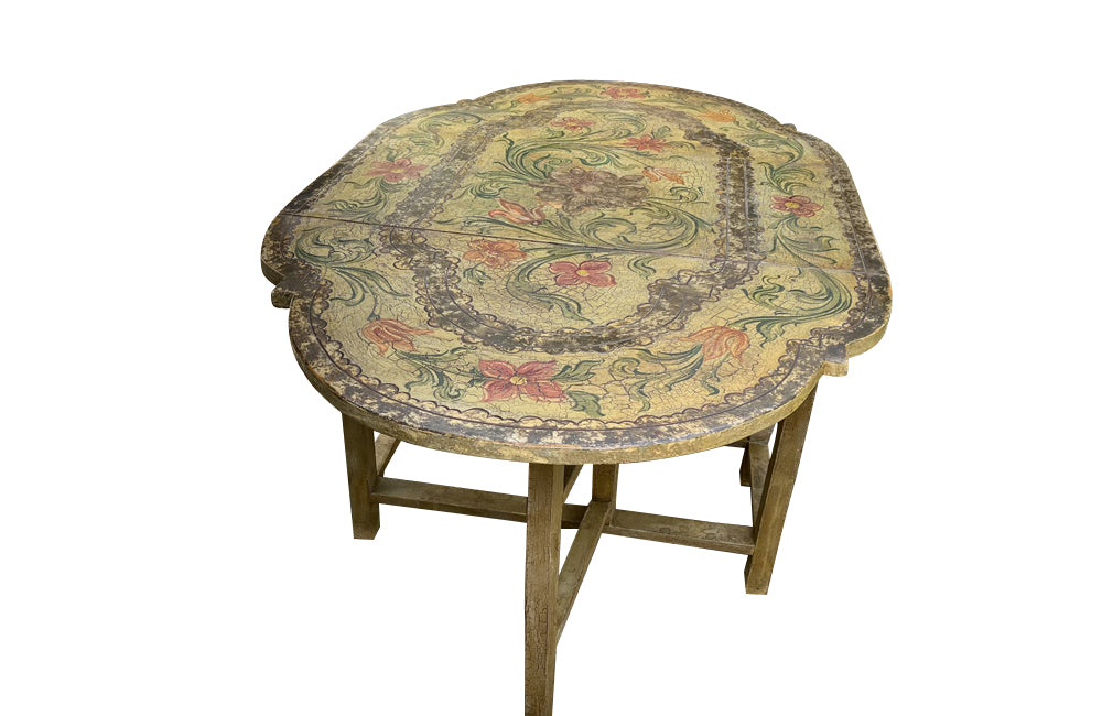 Antique table, painted, drop-leaf, Italian. hand-painted top decorated in scrolling foliate and floral motifs in warm ochre, green, lavender and terracotta tones.