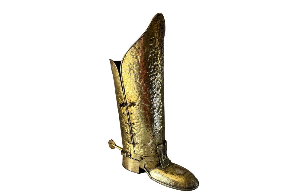 Decorative umbrella stand in the form of a large brass riding boot with brass laces to both sides, heel and spur.