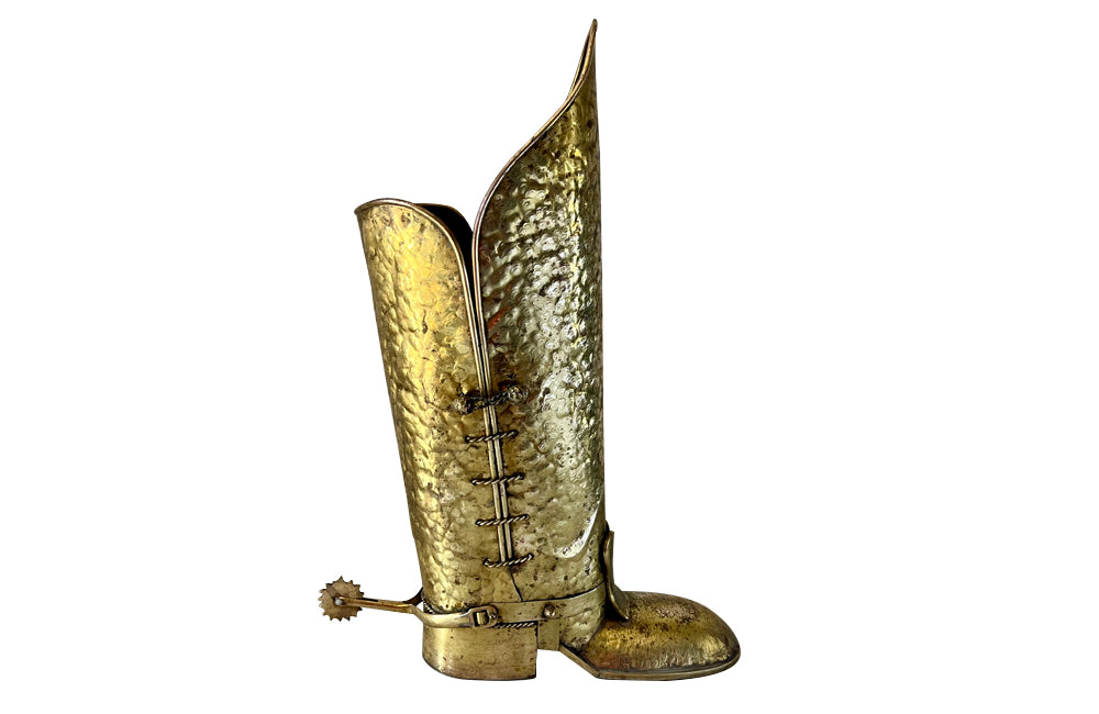 Decorative umbrella stand in the form of a large brass riding boot with brass laces to both sides, heel and spur.