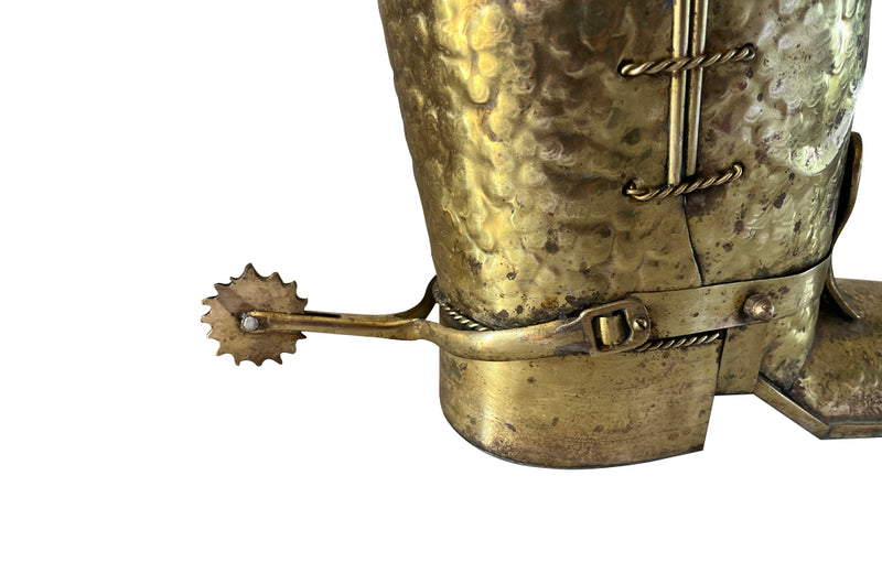 Decorative umbrella stand in the form of a large brass riding boot with brass laces to both sides, heel and spur.