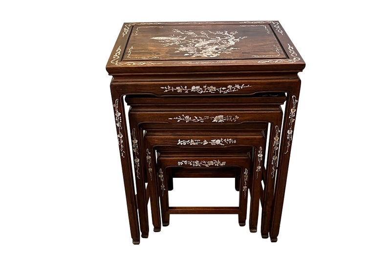 Nest of four Chinese  decorative teak occasional tables with inlaid mother of pearl inlay to the top and legs.