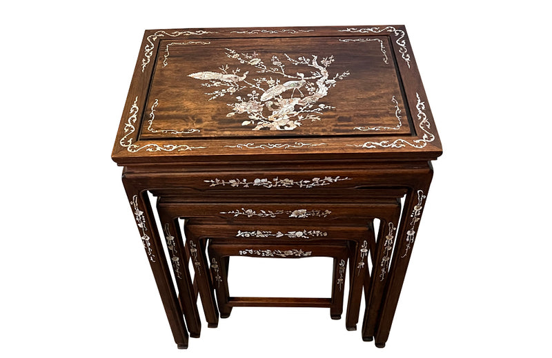 Nest of four Chinese  decorative teak occasional tables with inlaid mother of pearl inlay to the top and legs.