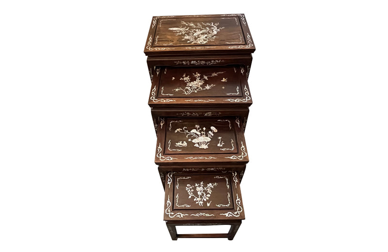 Nest of four Chinese  decorative teak occasional tables with inlaid mother of pearl inlay to the top and legs.