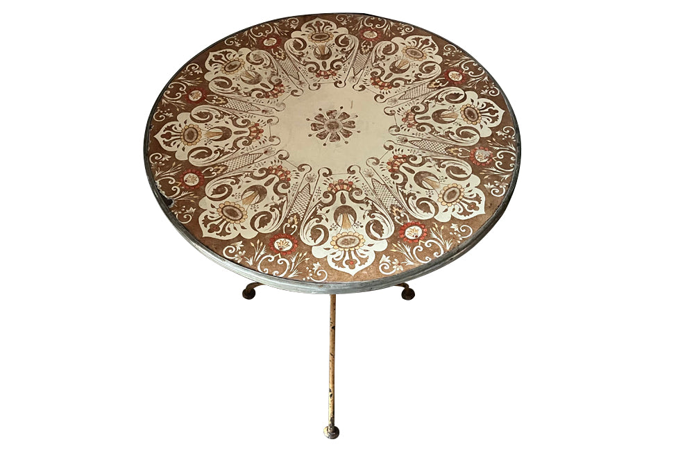 Rare, early 20th century French enamel top gueridon bistro table with iron tripod base and enamelled top featuring floral and foliate motifs.