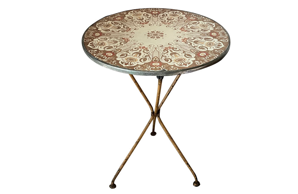 Rare, early 20th century French enamel top gueridon bistro table with iron tripod base and enamelled top featuring floral and foliate motifs.