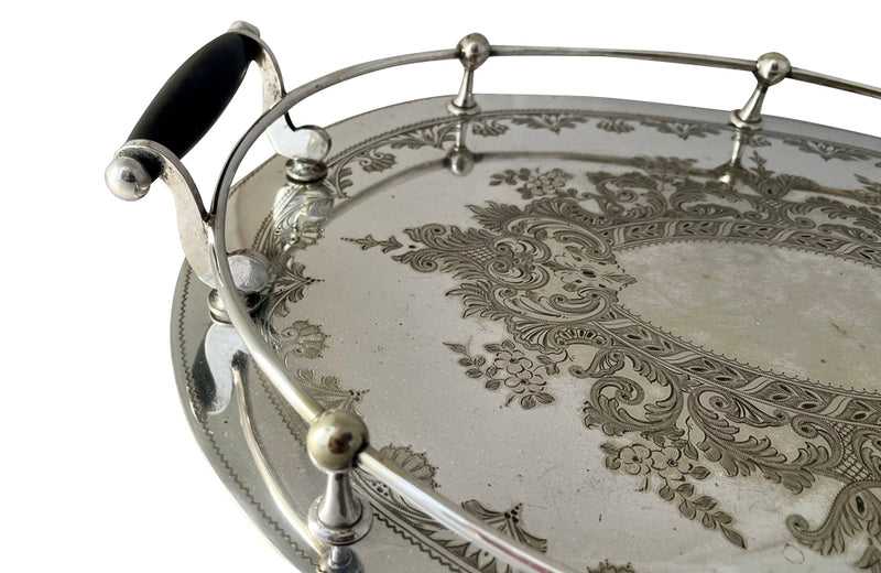 Elegant, silver plate tray with raised gallery and ebony handles engraved with floral and foliate decoration and empty central cartouche bearing the makers mark of Mackay Bros, Dundee.