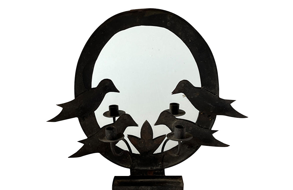 oval mirror in a metal folk art frame wiith two pairs of stylised birds, double branched candle holder and central tray to the base.