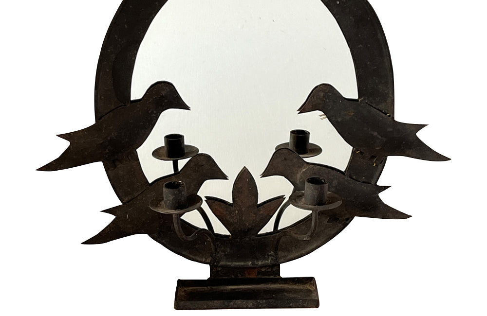 oval mirror in a metal folk art frame wiith two pairs of stylised birds, double branched candle holder and central tray to the base.