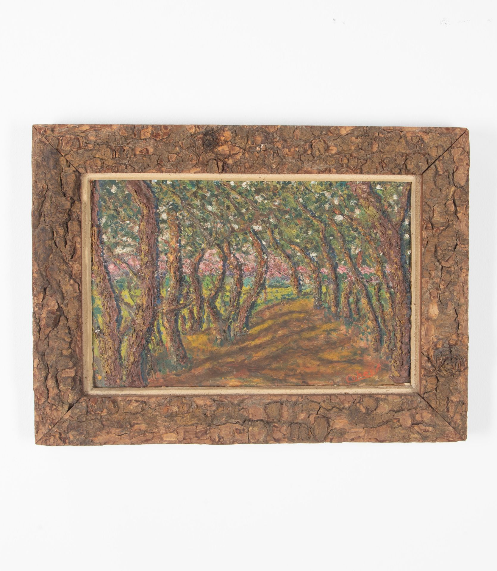 Oil on card painting of a shady forest path with pink blossoming trees signed by the artist to the lower right, Cohen