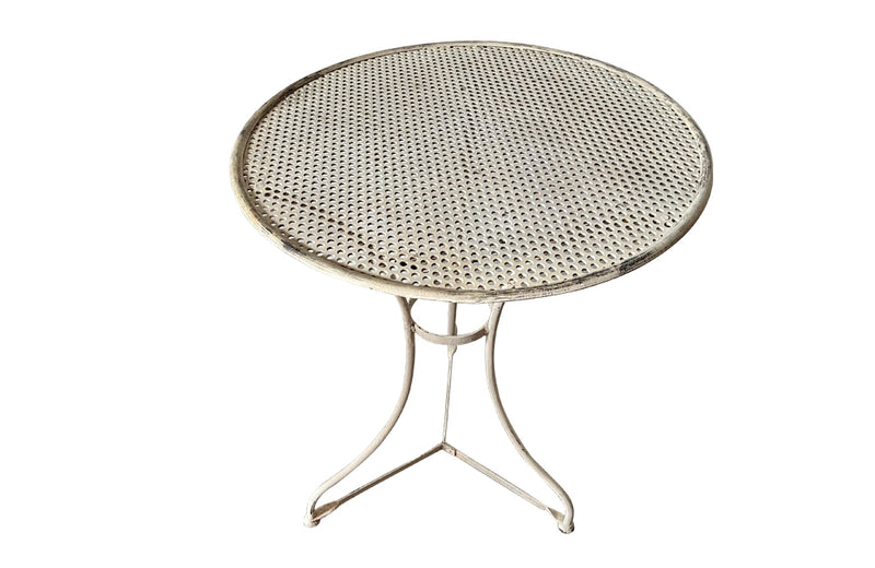 French iron garden table with pierced round top on tripod base with circular stretcher circa 1900