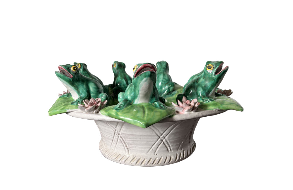 20th century glazed terracotta centrepiece in the form of a basket with seven open mouthed frogs on flowering water lily pads surrounding the rim. 