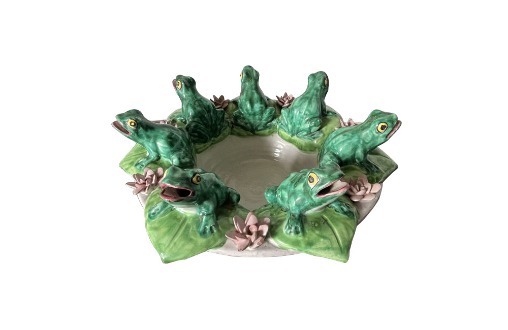 20th century glazed terracotta centrepiece in the form of a basket with seven open mouthed frogs on flowering water lily pads surrounding the rim. 