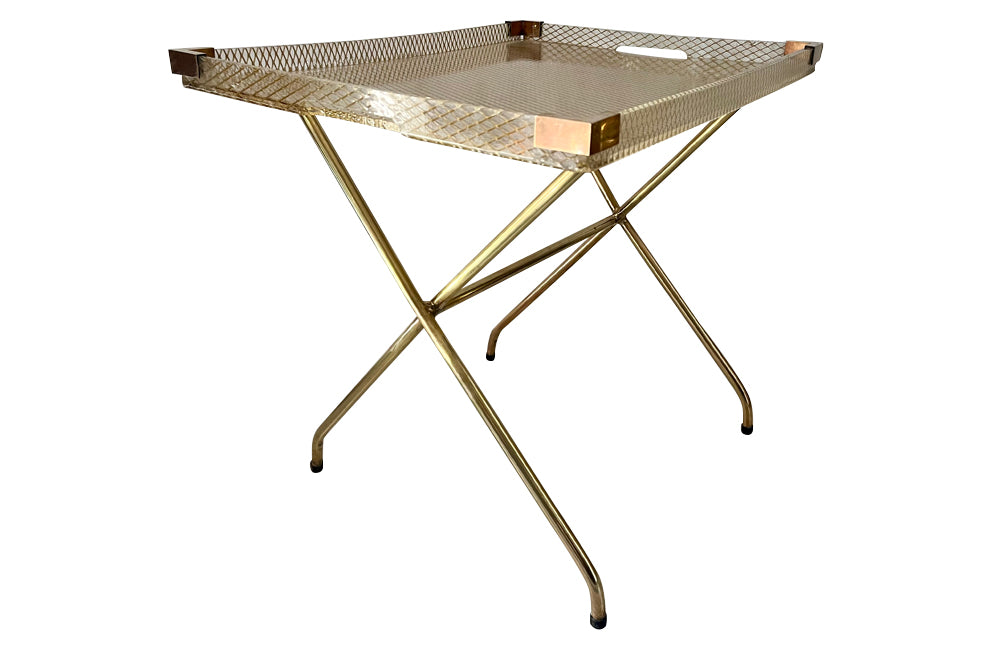 Large lucite tray with brass corners and embedded mesh with two incorporated handles sitting on a separate brass stand.
