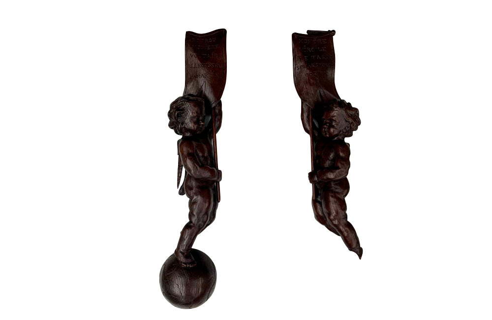 Pair of 19th century French hand carved cherubs bearing pennants inscribed with the names of famous literary figures.