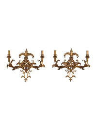 A decorative and elegant pair of 20th Century Italian gilt tole and wood wall lights.