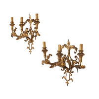 A decorative and elegant pair of 20th Century Italian gilt tole and wood wall lights.