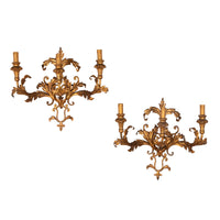 A decorative and elegant pair of 20th Century Italian gilt tole and wood wall lights.