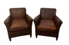 Charming pair of small 1920s French leather club chairs with squared backs and splayed arms.