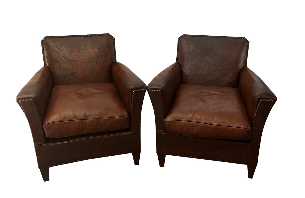 Charming pair of small 1920s French leather club chairs with squared backs and splayed arms.