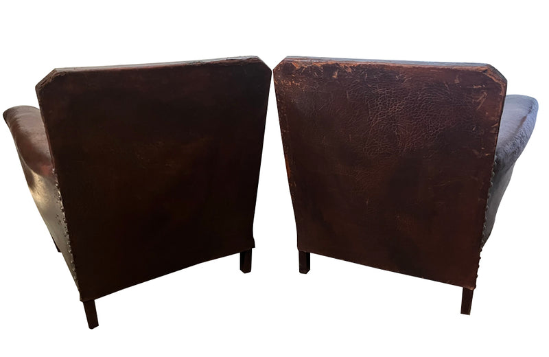 Charming pair of small 1920s French leather club chairs with squared backs and splayed arms.