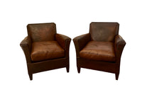 Charming pair of small 1920s French leather club chairs with squared backs and splayed arms.