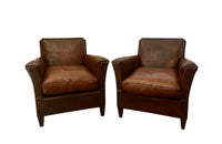 Charming pair of small 1920s French leather club chairs with squared backs and splayed arms.