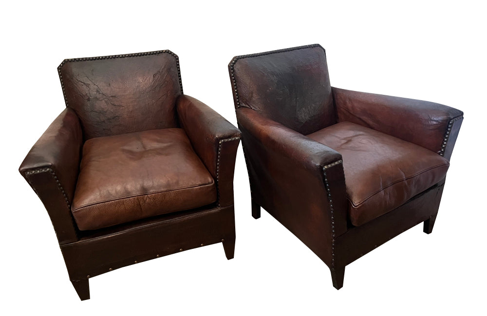 Charming pair of small 1920s French leather club chairs with squared backs and splayed arms.