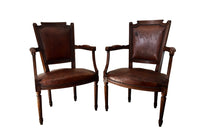 Elegant pair of 20th Century French comfortable worn leather armchairs in the Louis XVI style.