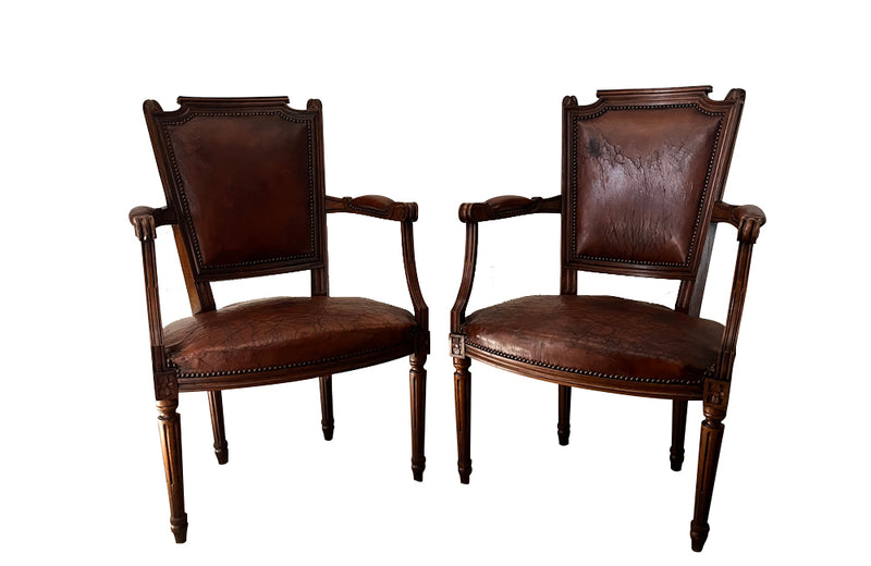 Elegant pair of 20th Century French comfortable worn leather armchairs in the Louis XVI style.