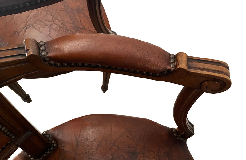 Elegant pair of 20th Century French comfortable worn leather armchairs in the Louis XVI style.